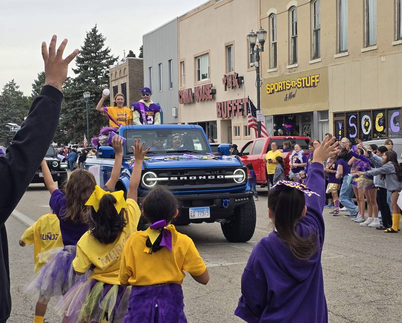 Mendota High School senior homecoming attendant Ella Coss tosses a ball Friday, Sept. 27, 2024, to the parade crowd.