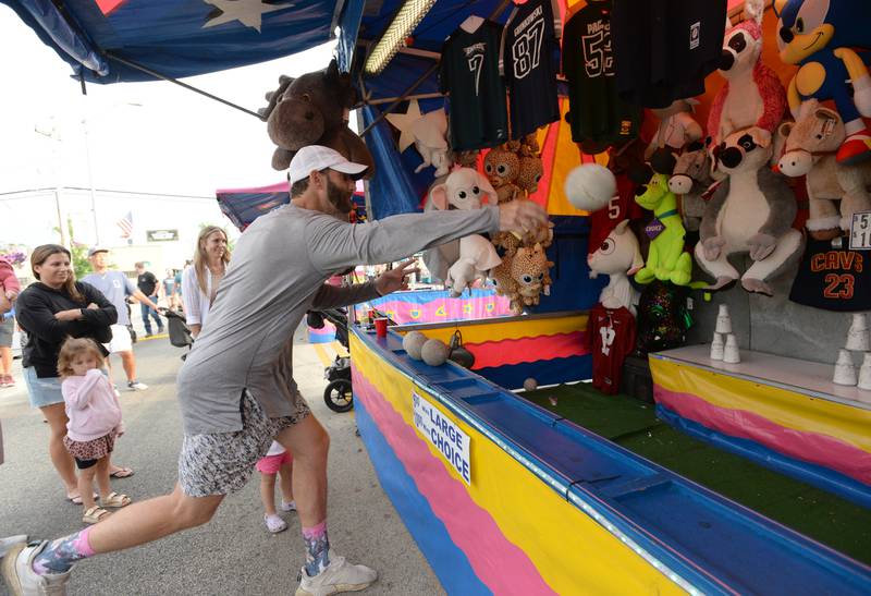 People including Sam Reindl of Downers Grove try to win a prize during the Taste of Westmont Friday July  8, 2022.