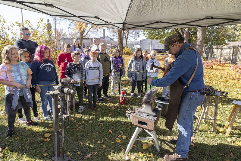 John Deere Historic Site blacksmith David Sheely shows Reagan Middle School fourth graders how the plow maker himself would have crafted tools out of iron so many years ago. The smithing demonstration is one of the more popular stops on the tour.