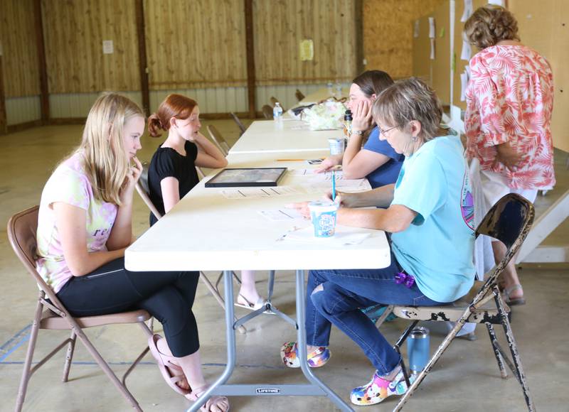 Judges meet with 4-H kids in the commercial barn at the Marshall-Putnam 4-H Fair on Wednesday, July 9, 2023 in Henry.