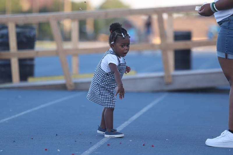 Kaidence Collins, one-years-old, throws party poppers before the fireworks start at Joliet Memorial Stadium in on Thursday July 4, 2024.