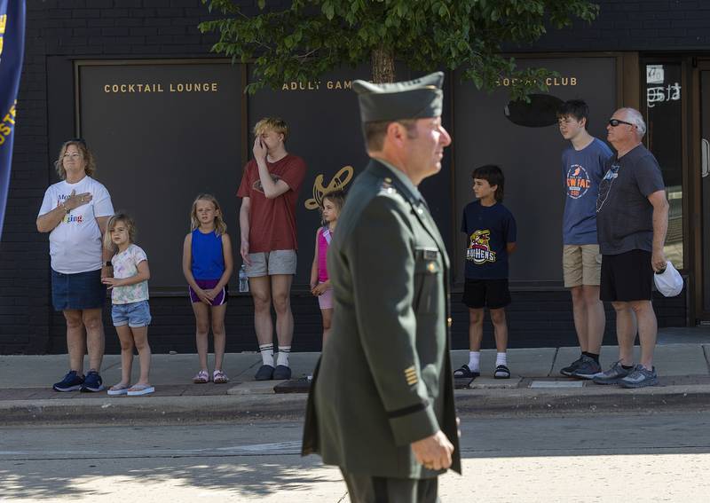 Parade watchers stand with respect as the color guard passes Monday, May 25, 2026, for Dixon’s Memorial Day observance.