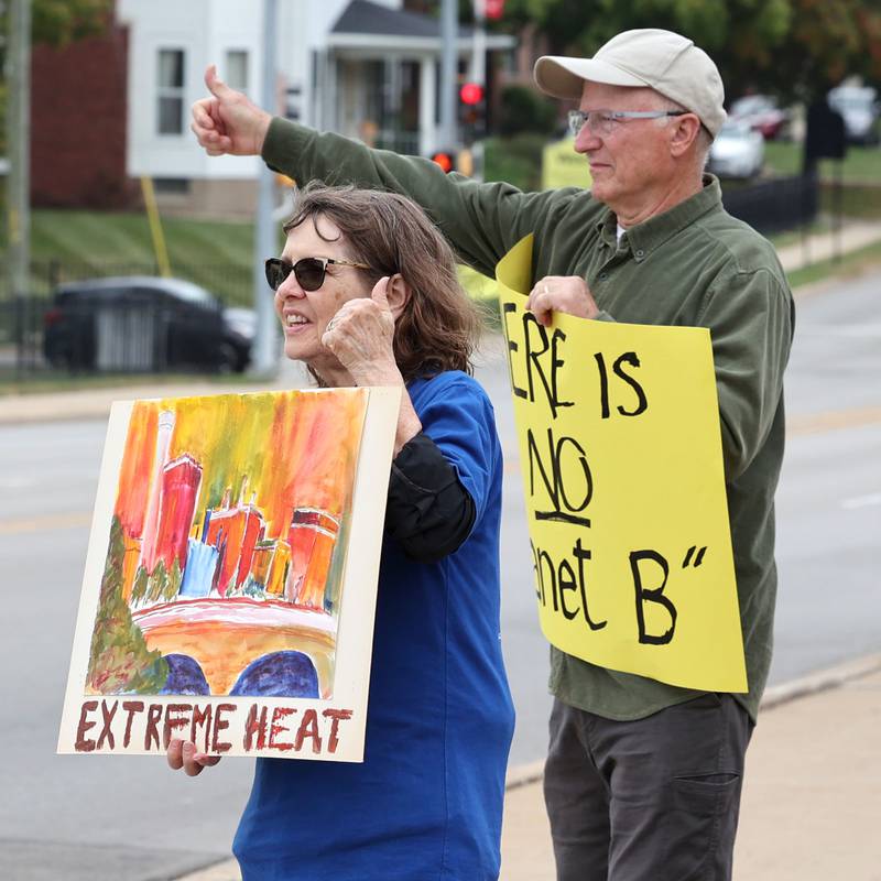 Alfred Mueller, from Sycamore, and Nancy Proesel, from DeKalb, gives thumbs up to a passing motorist who honked their horn during a rally Saturday, Sept. 16, 2023, at Memorial Park in downtown DeKalb. The demonstration was held to push legislators to promote alternative forms of energy and lessen the use of fossil fuels.