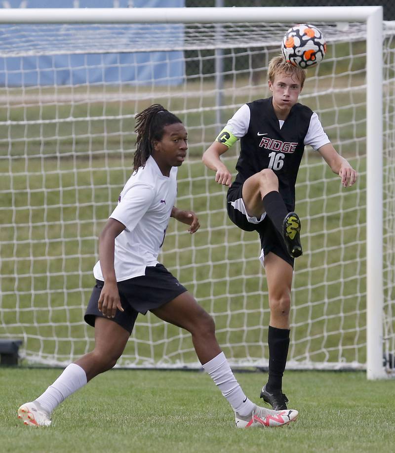 Prairie Ridge's Kaj Justesen kicks the ball away as he is defended by Hampshire's Shamar Allwood during a Fox Valley Conference soccer match Tuesday, Sept. 19, 2023, at Prairie Ridge High School in Crystal Lake.