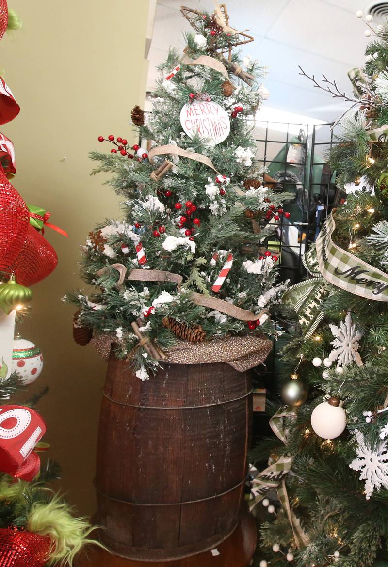 A whiskey barrel Christmas tree is on display on Tuesday, Nov. 12, 2024 at Upsale Resale in Spring Valley.  For over 17 years the business has hosted a yearly Christmas Tree and Decor Auction, featuring unique items and themed trees that customers can add to their collections. The items will be on display in the window of the business, located at 214 W. St. Paul St. in Spring Valley. The auction takes place Thursday from 10a.m.-2p.m. Proceeds from the auction will go toward Upscale’s Helping Hands Charity to help out local communities.