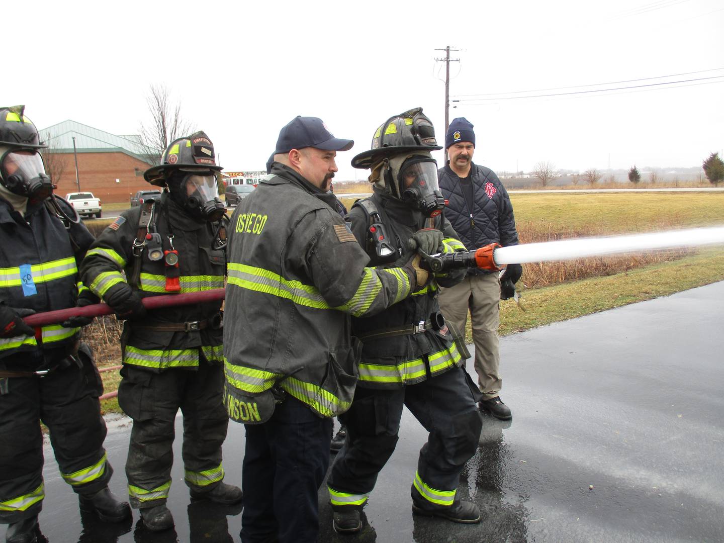 U.S. Rep. Lauren Underwood, D-Naperville, trains a fire hose on a burning car during a training session with the Oswego Fire Protection District on March 19, 2022 at the Montgomery station. (Mark Foster -- mfoster@shawmedia.com)