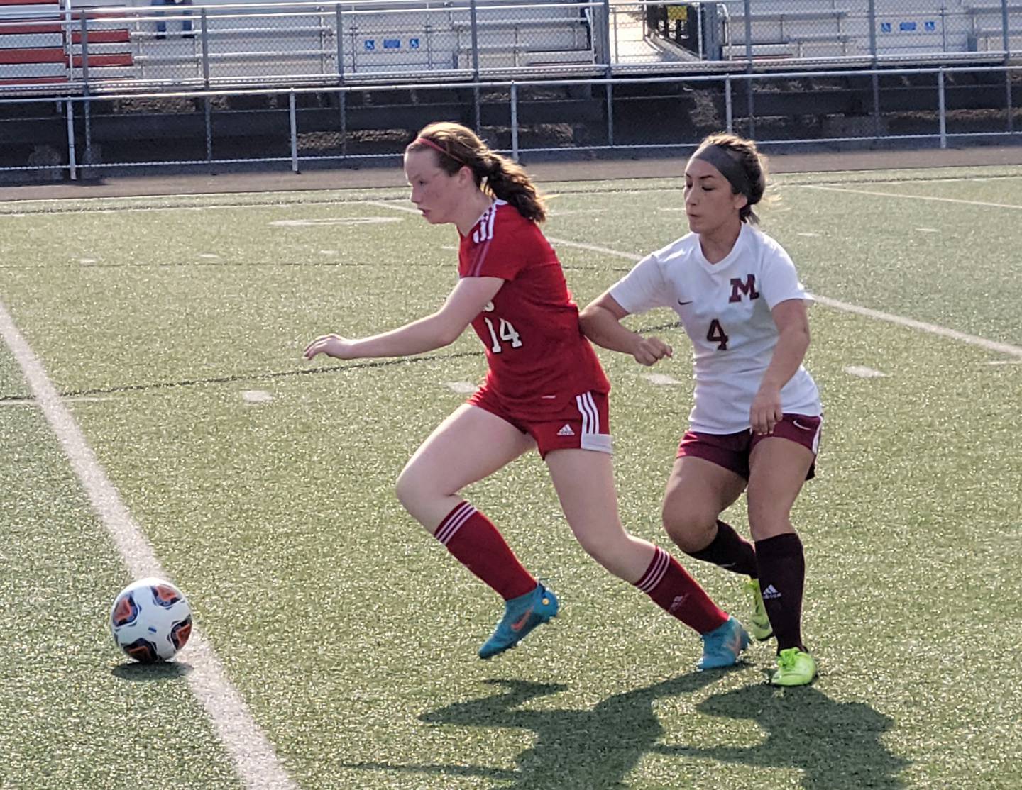 Streator's Bridget McGurk (14) looks for an open teammate as Morris' Adrana Plascencia (4) defends during the Class 2A regional semifinal Wednesday, May 18, 2022, at Washington High School.