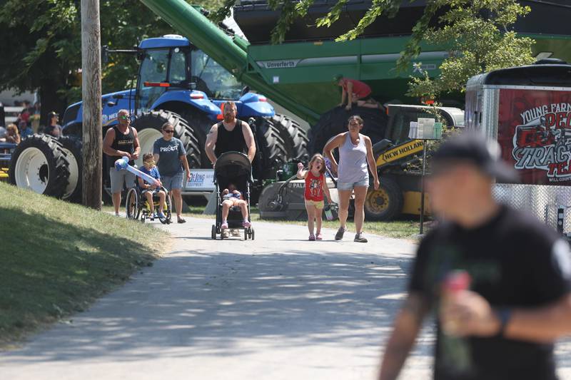Families walk along farm equipment on display at the Will County Fair on Sunday, August 25, 2024 in Peotone.