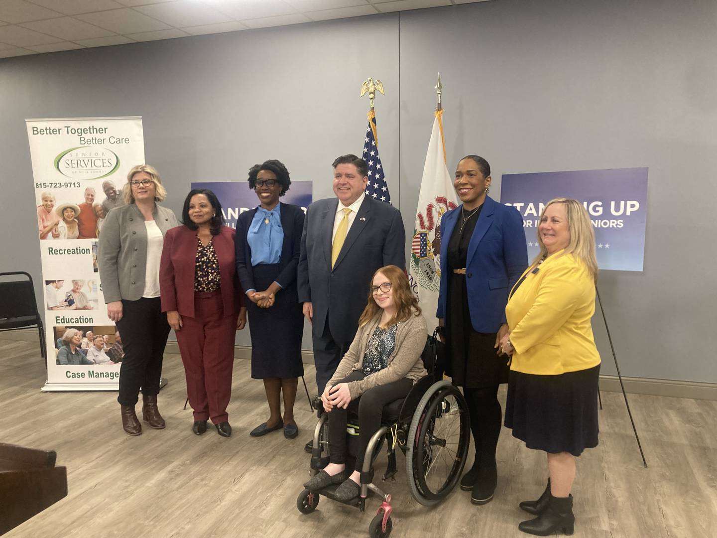 Gov. JB Pritzker , Lt. Gov. Julianna Stratton, U.S. Rep. Lauren Underwood, Will County Seniors CEO Brianne Hetman, Illinois Department on Aging Director Mary Killough, AgeGuide CEO Marla Kronczak, and Disability Resource Center Independent Living Advocate Riley Spreadbury gather for a photo at the Ovation Center on the Standing Up For Illinois tour. 
Thursday, March 20, 2025.