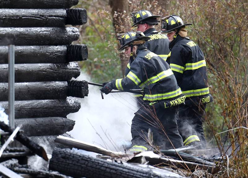 Somonauk firefighters pull smoking debris from a house that was destroyed by fire Thursday, Nov. 13, 2025, near Shabbona Grove Road in Shabbona. Several local departments responded to the general alarm structure fire.