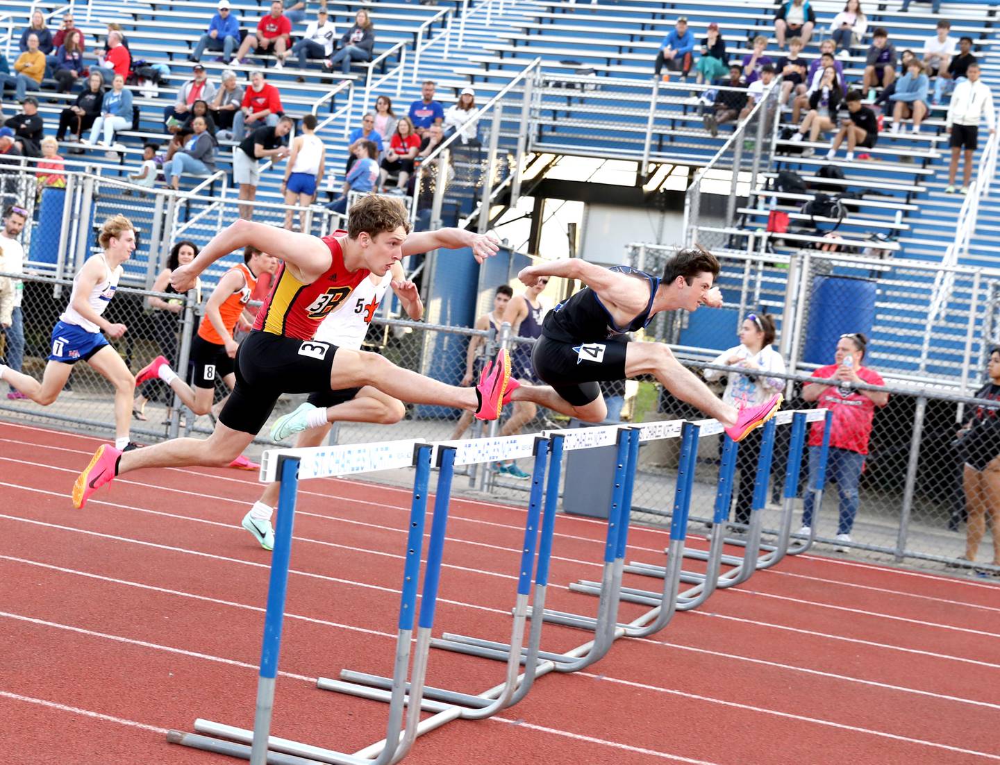 St. Charles North’s Bryce Thomas (right) and Batavia’s Ben Mathews compete in the 110-meter hurdles during the Kane County Championships track and field meet at St. Charles North on Friday, May 5, 2023.
