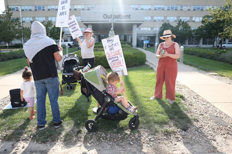 Laura Fitzgerald, a nurse at St. Joseph, takes a photo of her 4-year old son, Leon, as he holds a picket sign outside St. Joseph Hospital as nurses contract negotiations continue on Thursday, July 20th, 2023 in Joliet.