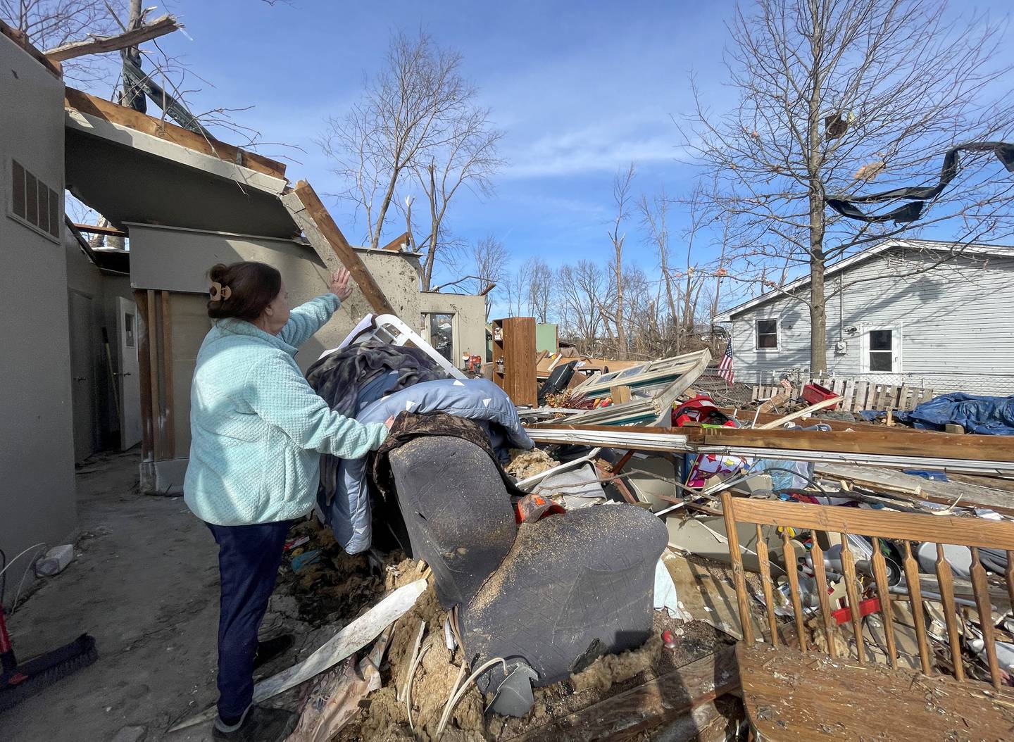 Aroma Park resident Patricia Kime stands in what was her living room at her home on Strasma North Drive recounting the the March 10 EF-3 tornado that destroyed many homes in the area.