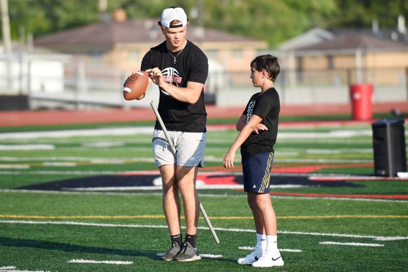 Ethan Kohl, left, instructs Liberty Intermediate sixth grader Cole Roseborough at the Bradley-Bourbonnais quarterback camp Wednesday, July 2, 2025.