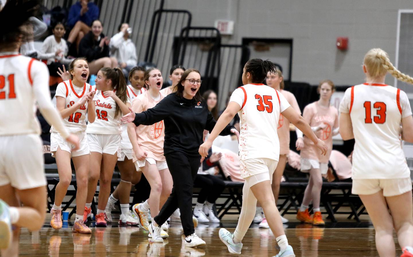 St. Charles East's head coach Katie Claussner congratulates her team between quarters during a game against Wheaton Warrenville South on Tuesday, Feb. 11, 2025 in St. Charles.