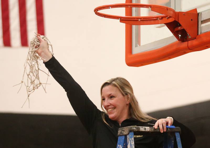 St. Bede head girls basketball coach Stephanie Mickley smiles while cutting down the net after defeating Serena in the Class 1A Sectional final game on Thursday, Feb. 22, 2024 at Gardner-South Wilmington High School.