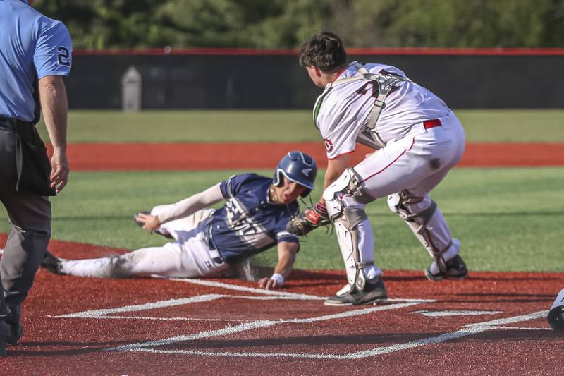 Oswego East's Dominic Battista (14) is tagged out at the plate after sliding in head first during baseball game between Oswego East at Yorkville. Monday, May 12, 2025 in Yorkville.