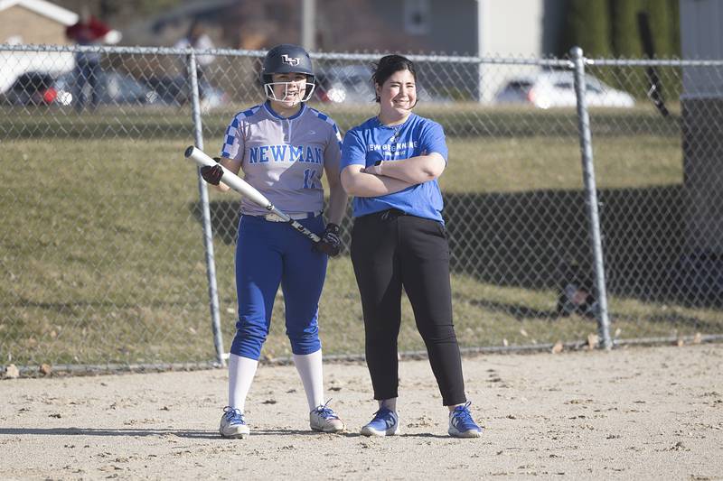 New Newman head softball coach Madison Koerner speaks with player Amiya Rodriguez in their opening game against Forreston Monday, March 11, 2024.