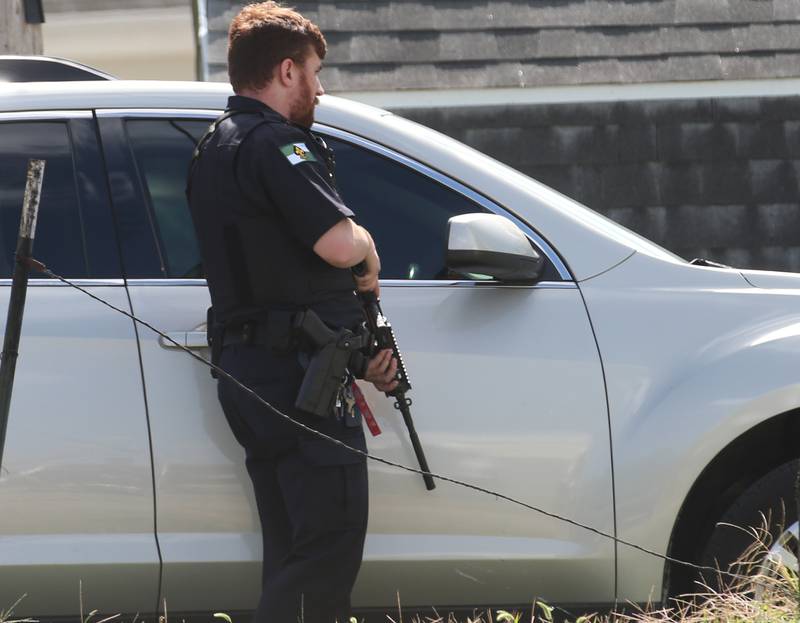 An Ottawa Police officer has his gun drawn in an alleyway near Scott street and U.S. 6 on Wednesday, Sept, 13, 2023 in Ottawa. A standoff with a suspect occurred in the 1500 block of Scott Street around noon.