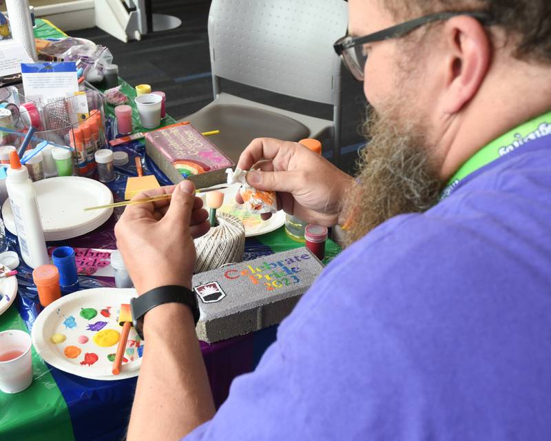 John Wohlers a Waubonsee Community College employee paints a brick during the pride party held at Waubonsee Community College Plano’s campus on Thursday June 29, 2023.