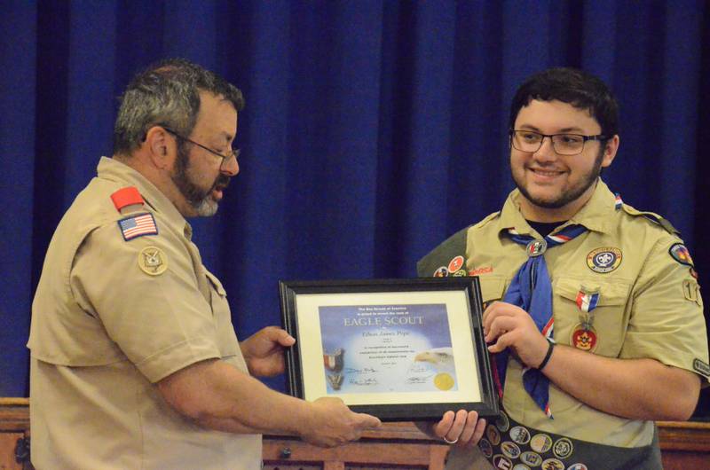 Ethan Pope, right, of Montgomery, receives his Eagle Scout certificate from Blackhawk Troop 11 Scoutmaster Rick Scalzo. Pope's recognition took place at Wesley United Methodist Church in Aurora. Pope, 18, joined Boy Scouts as a first grade student.