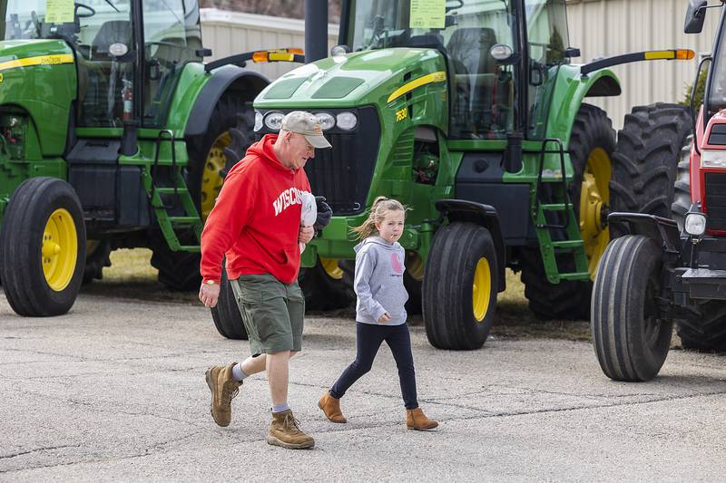 Vic Sebastiano and granddaughter Ally Zimmerman of Lee pass by s display of tractors Saturday, March 15, 2025, in Sublette. Full-size tractors were also put on display next to their tiny counterparts over the weekend for the festival.