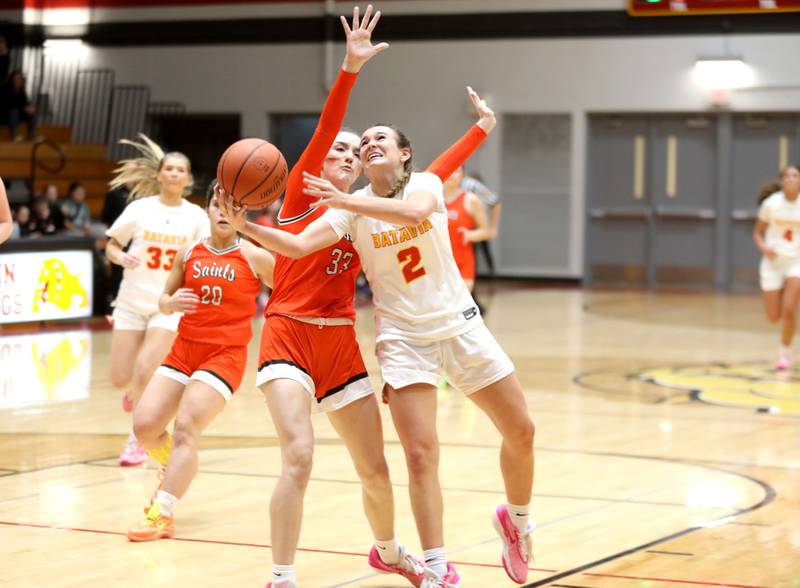 Batavia’s Brooke Carlson (right) attempts a shot from under the basket against St. Charles East’s Sofia O’Sullivan during a game at Batavia on Thursday, Feb. 1, 2024.
