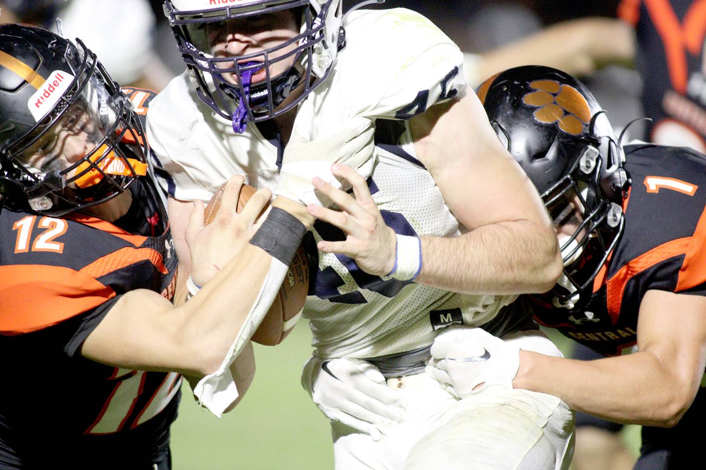 Cary-Grove’s Logan Abrams moves the ball as Crystal Lake Central’s Rene Gaunaurd, left, moves in for a tackle in varsity football at Metcalf Field in Crystal Lake Friday night.