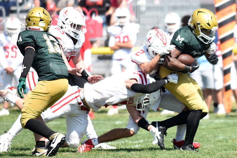 Bishop McNamara's Julius May, right, runs through a host of Lawrenceville defenders on the way to the endzone for his third touchdown in a game at Bishop McNamara Saturday, Aug. 30, 2025.