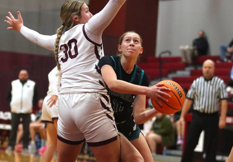 Woodstock North’s Abigail Ward moves with the ball as Marengo’s Macy Noe defends in varsity girls basketball on Tuesday, Dec. 2, 2025, at Marengo High School in Marengo.