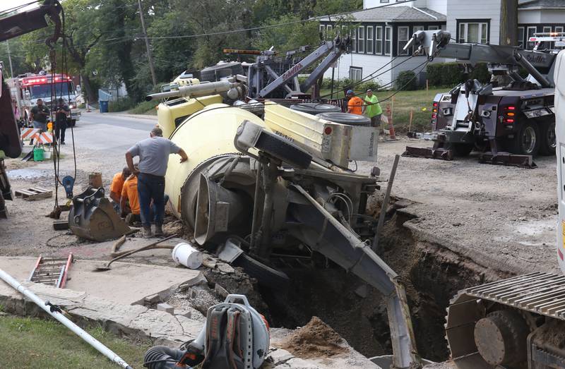 Crews with Scholles Body Shop use tow trucks to lift a cement truck out of a sinkhole on Tuesday, Sept. 2, 2025 at the intersection of Pulaski Street and 6th Streets in Peru.