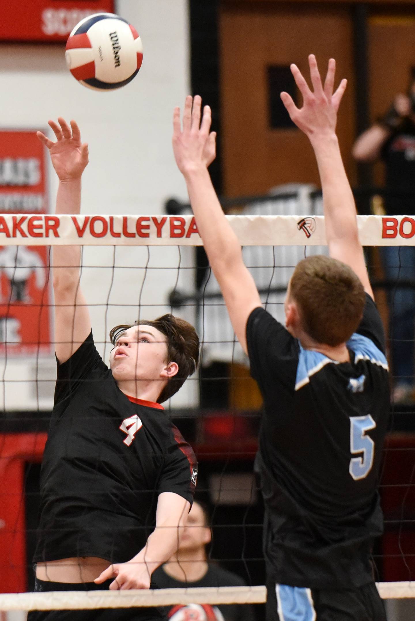 Bradley-Bourbonnais' Cooper Yuska, left, looks to send a hit past Kankakee's Asa Chandler during a game at Bradley-Bourbonnais Thursday, April 9, 2026.