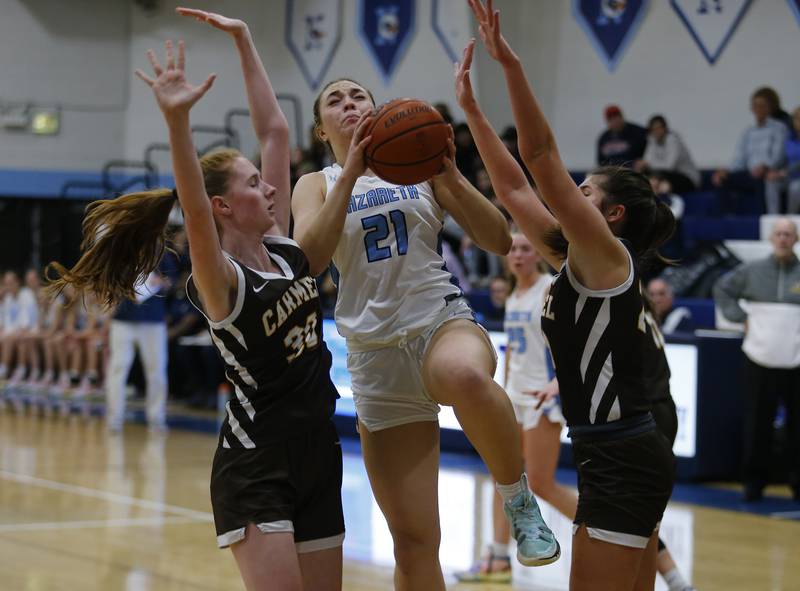 Nazareth's Olivia Austin (21) splits the defense during the girls varsity basketball game between Carmel High School and Nazareth Academy on Wednesday, Dec. 7, 2022 in LaGrange, IL.