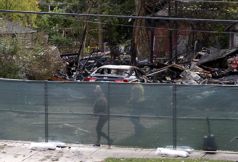 Monica Diaz is escorted to her home on Tuesday, October 10, 2023, after an explosion following a gas leak in the area leveled one home as caused several fires.