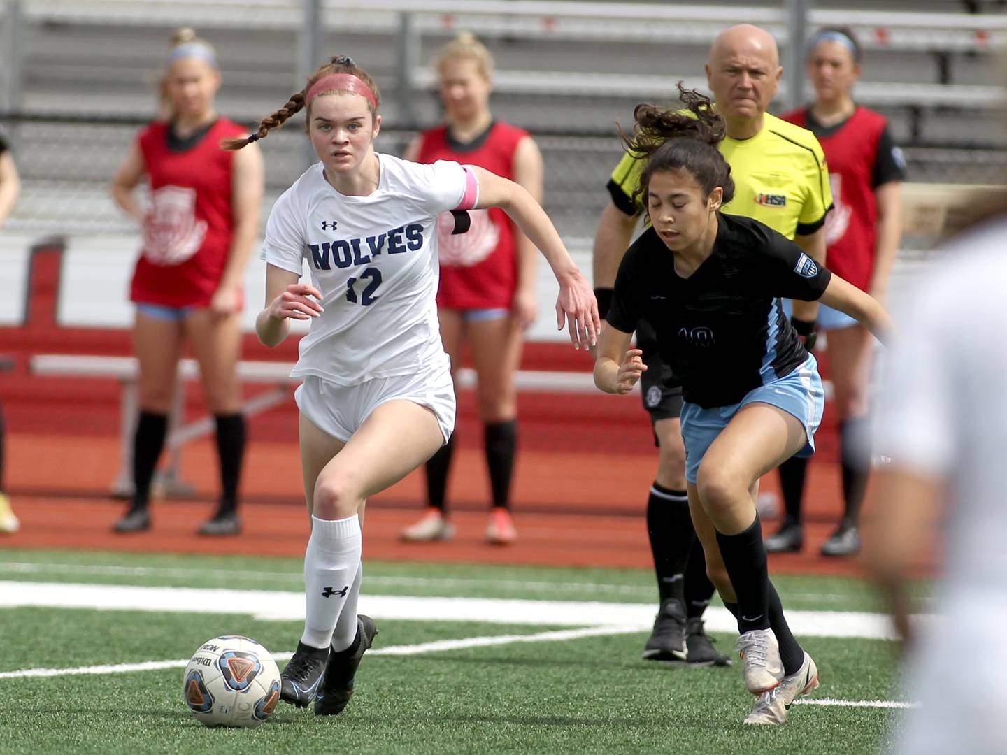 Oswego East’s Chloe Noon (12) and St. Charles North’s Juliana Park chase after the ball during a Naperville Invitational game at Naperville Central on Saturday, April 23, 2022.