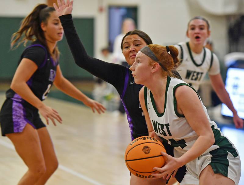Glenbard West’s Sophia Evans drives to the basket as Downers Grove North’s Gianna Goodwin defends during a game against Downers Grove North on December 4, 2025 at Glenbard West High School in Glen Ellyn.