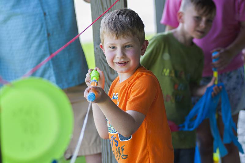 Blake Halgren, first grader at St. Anne’s School in Dixon, pushes a handmade jellyfish across a line with a stream of water during a day of fun at the school. The school celebrated the school year with a day of STREAM activities.
