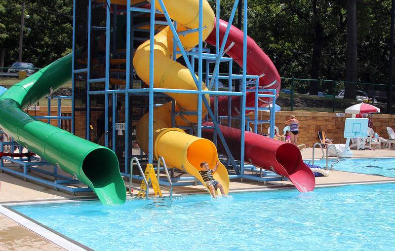 A young patron comes off one of Morris City Pool's three water slides. The pool has seen record attendance this summer.