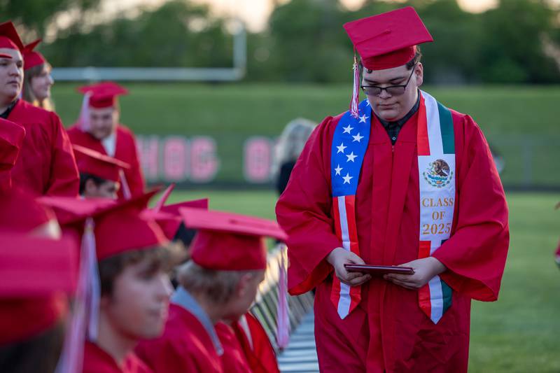 Jose Rodriguez walks to seat holding diploma on Friday May 23, 2025 at Ottawa High School in Ottawa.