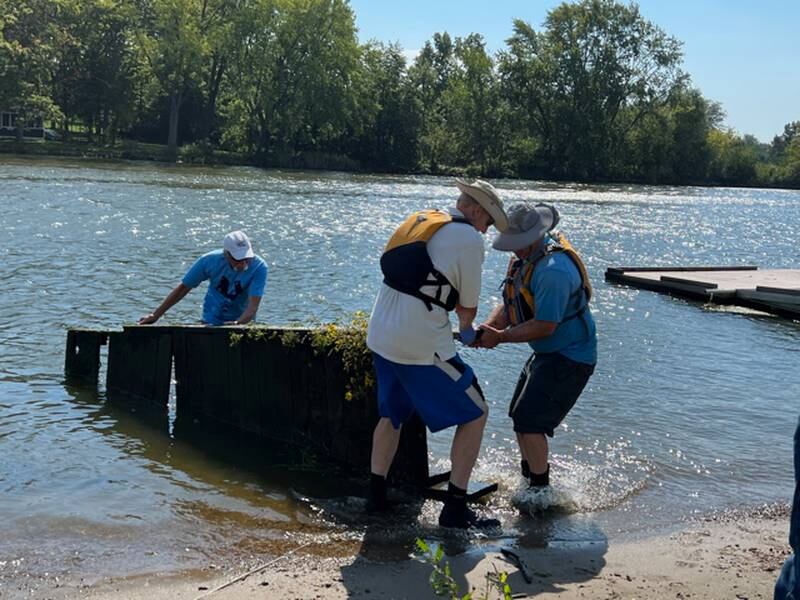 Members of the St. Charles Canoe Club on Sept. 17 remove an old dock from the Fox River during the "It's Our Fox River" cleanup.