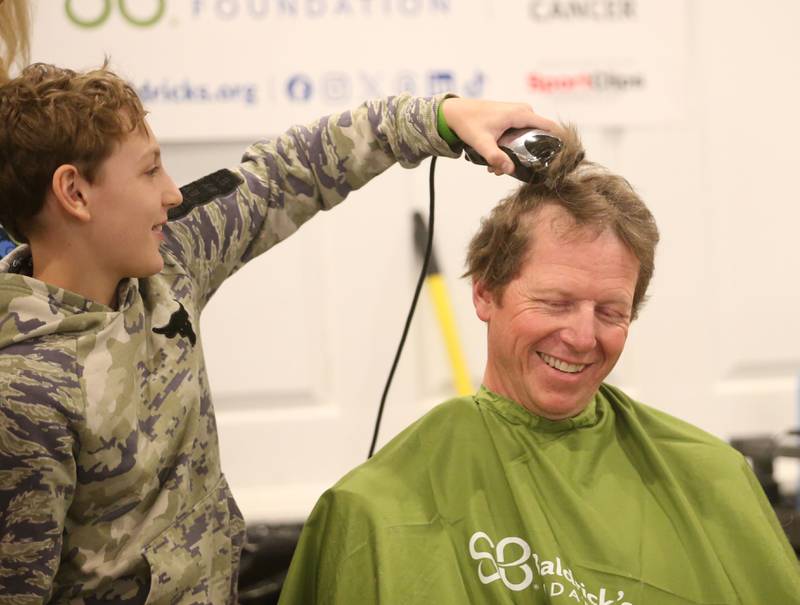 Collin Duffiele takes the "first swipe" of hair off of Jake Marsala during the 18th annual Illinois Valley Emergency Services St. Baldrick's event on Sunday, March 23, 2025 at Senicas Oak Ridge in La Salle.