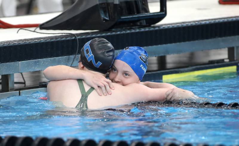 St. Charles North’s Kate Farrell (right) hugs teammate Isabelle Beu following the 200-yard individual medley championship heat during the IHSA Girls State Championships on Saturday, Nov. 16, 2024 at FMC Natatorium in Westmont.