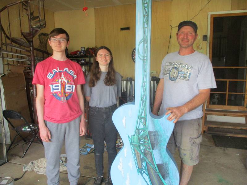 The Benedicks (from left), Jonah, Sofia and Jeff, stand with the guitar they painted in the garage at their home for the Ready to Rock street art exhibit in Joliet. May 27, 2023.