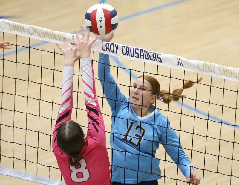 Marquette's Lucy McGrath spikes the ball as Serena's Rebekah Shugrue leaps up to get a piece of it on Wednesday, Oct. 22, 2025 in Bader Gymnasium at Marquette High School.
