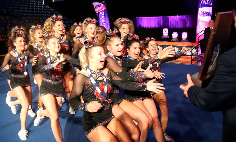 Members of the Crystal Lake Central cheerleading team run to grab the third-place trophy in the medium team Competitive Cheerleading State Final Competition on Saturday, Feb. 3, 2024 at Grossinger Motors Arena in Bloomington.