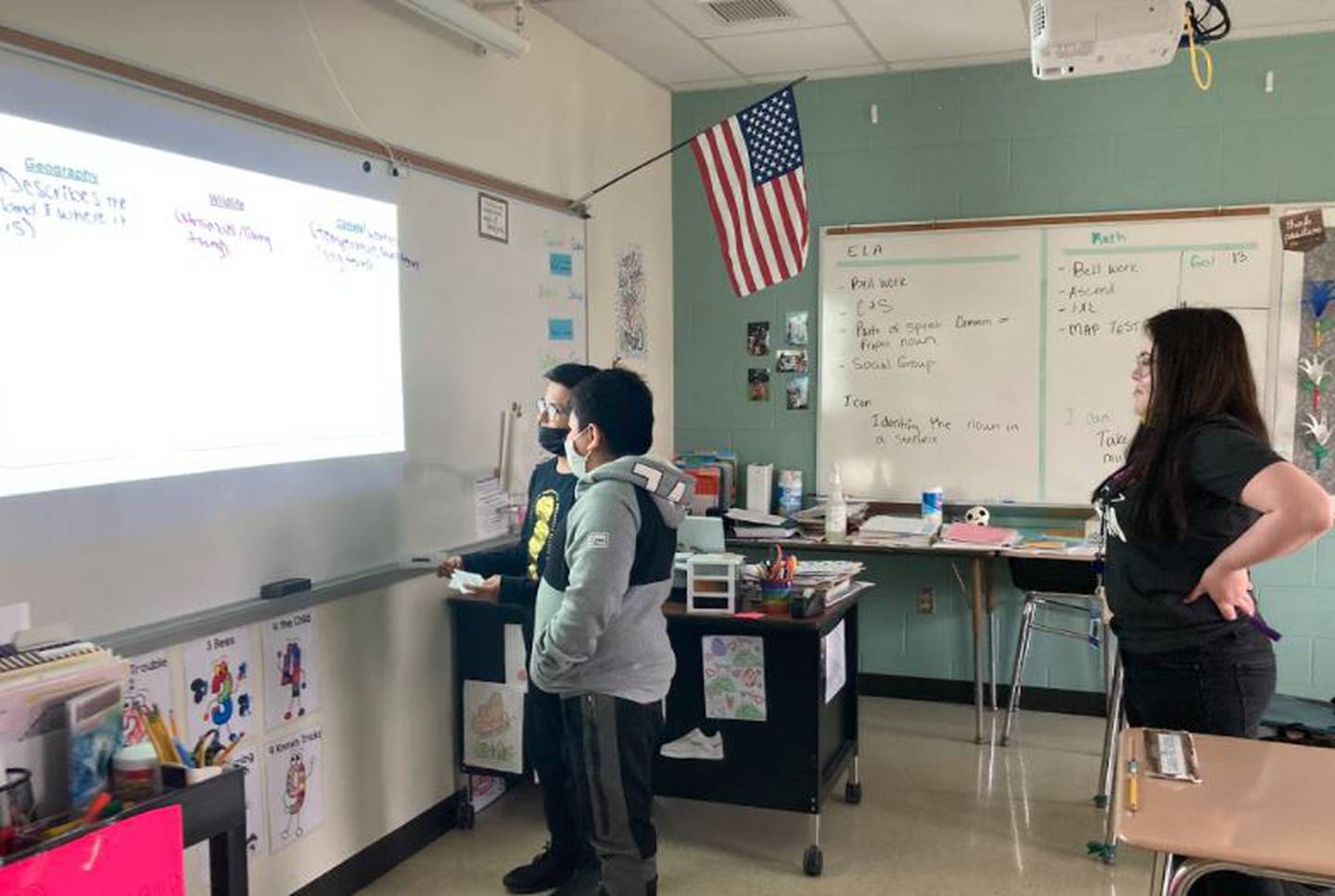 Jackie Martinez, a teacher in Minooka School District 201's multilingual program, works with sixth-graders Dominic and Osiel to sort vocabulary words as a team.