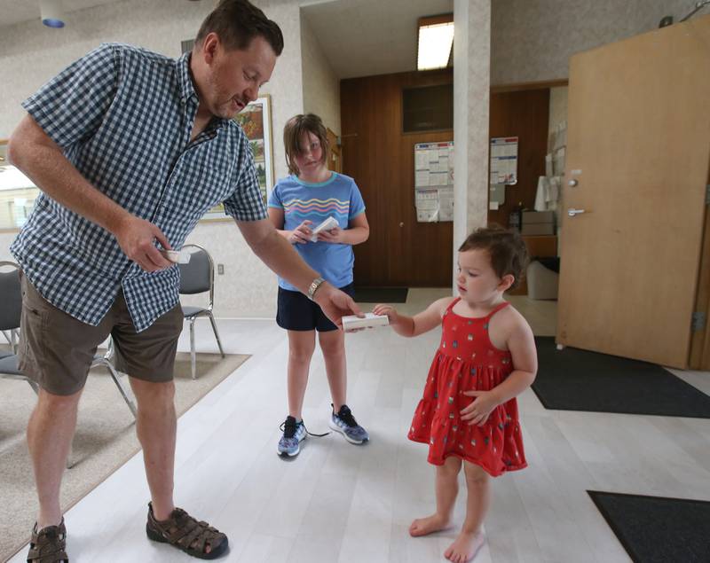 Oglesby mayor Jason Curran hands Remi Eichelkraut and her sister Rylan ice cream bars on Wednesday, Aug. 23, 2023 at the Oglesby City Hall. Mayor Curran celebrated his birthday by handing out free ice cream bars and popsicles as a treat to beat the heat.