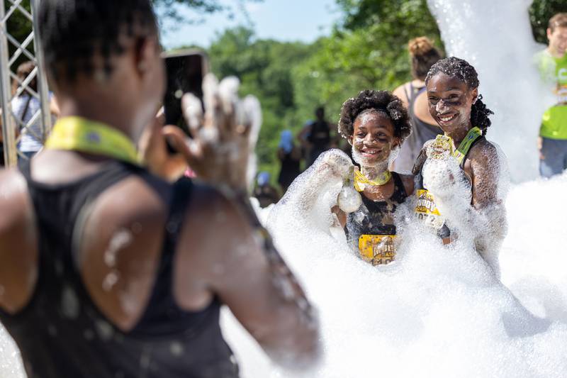 (left to right) Janasha Eakins takes photo of Iman Eakins and Milan Eakins after finishing the 2025 Muddy Dash on Saturday, June 28, 2025 at Fox Valley Off Road in Utica.
