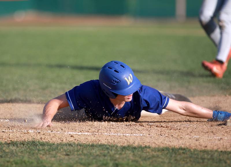Wheaton North's Zander Zielinski slides safely into first base during a game against St. Charles East on Wednesday, April 23, 2025 in St. Charles.