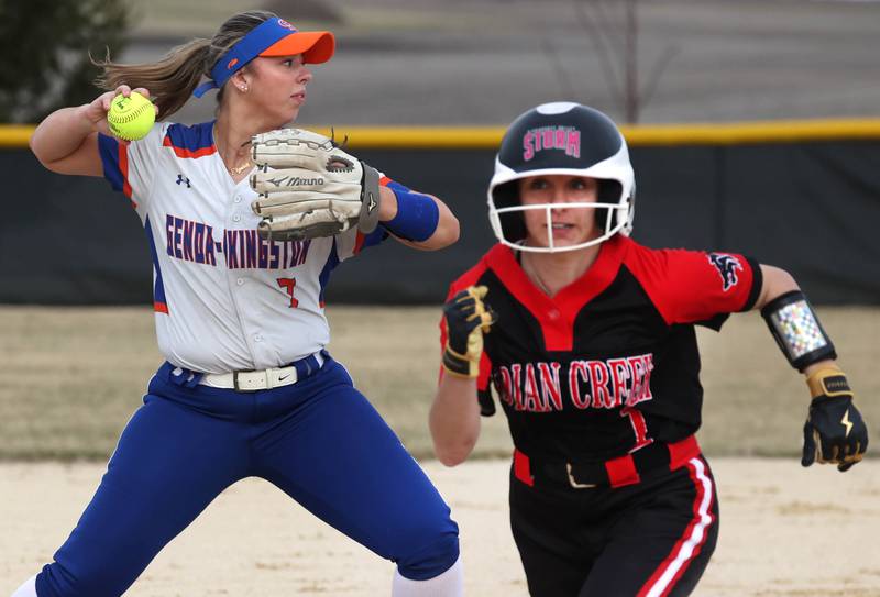 Genoa-Kingston’s Elizabeth Davis throws to first as Indian Creek’s MaKenna Barshinger goes to third during their game Tuesday, March 18, 2025, at Indian Creek High School in Shabbona.